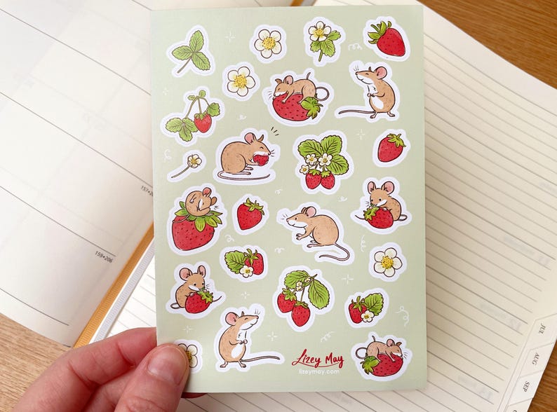 May include: A sheet of stickers featuring cute cartoon mice eating strawberries. The stickers are on a light green background with white outlines. The stickers are perfect for adding a touch of whimsy to your planner, journal, or laptop.