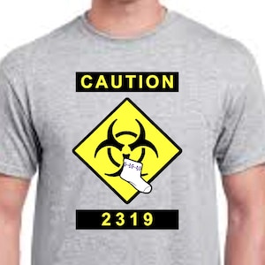 May include: A grey t-shirt with a yellow caution sign featuring a biohazard symbol and a white sock with purple flowers. The text "CAUTION" and "2319" are printed on the shirt.