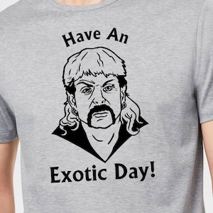 May include: A grey t-shirt with a black and white illustration of a man with a blonde mullet and mustache. The text "Have An Exotic Day!" is printed on the shirt.