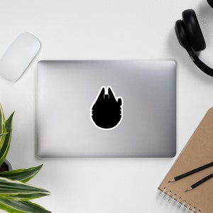 Könnte beinhalten: Schwarze Silhouette des Raumschiffs Millennium Falcon aus Star Wars.
