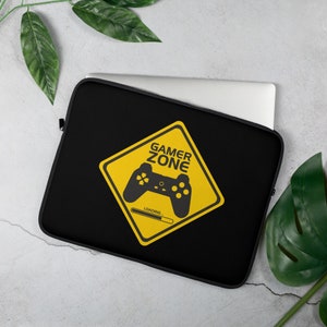 Op de afbeelding: Zwarte laptophoes met een geel ruitvormig waarschuwingsbord met de tekst "Gamer Zone" met een videogamecontroller in het bord en een voortgangsbalk met de tekst "Laden..."