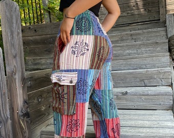May include: Patchwork pants with a colorful, geometric pattern. The pants have a wide leg and a drawstring waist. The fabric is a blend of cotton and linen.