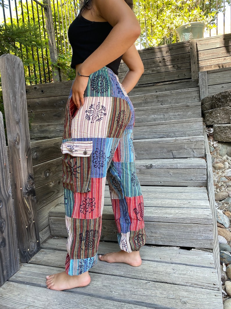 May include: Patchwork pants with a colorful, geometric pattern. The pants have a wide leg and a drawstring waist. The fabric is a blend of cotton and linen.