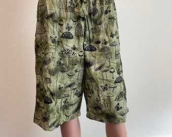 May include: Green shorts with a black mushroom and butterfly print.