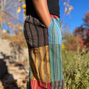 May include: Multicolored striped pants with a patchwork design. The pants are made of a soft, comfortable fabric and have a relaxed fit.