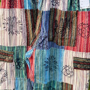 May include: Patchwork pants with a variety of colorful stripes and floral patterns. The pants have two pockets on the front.