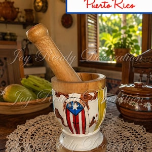 May include: A wooden mortar and pestle set featuring a hand-painted design of the Puerto Rican flag on the exterior. The mortar has a flared base and a natural wood rim, while the pestle is a solid, cylindrical wooden tool for grinding.