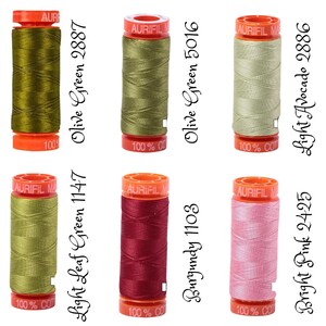 May include: Six spools of 100% cotton thread in various colors, including green, burgundy, and pink. The spools are labeled with the thread color and number.  The thread is made by Aurifil.