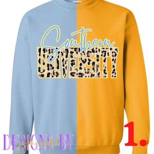 May include: A light blue and gold sweatshirt with the text "Southern University" in a leopard print design. The text is in a blue and yellow font.