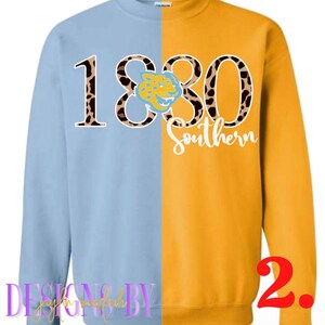 May include: A light blue and gold sweatshirt with the number 1880 in leopard print with a jaguar mascot in the middle and the word "Southern" below. The sweatshirt is a split design with the left side light blue and the right side gold.