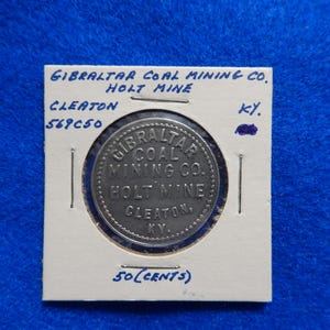 May include: A silver token with the text "Gibraltar Coal Mining Co. Holt Mine Cleaton Ky." and "50 (Cents)" on a white background.