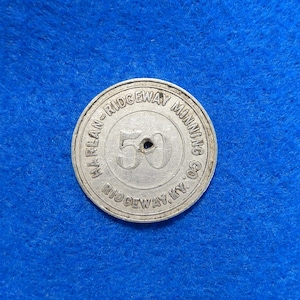 May include: A silver token with the text "Harlan-Ridgeway Mining Co. Ridgeway, Ky." and the number "50" in the center.