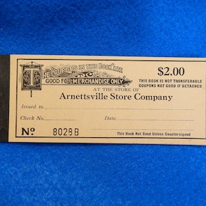 May include: A vintage coupon book for Arnettsville Store Company. The book is tan with black text and a black border. The book is worth $2.00 and has a number 8028 B.