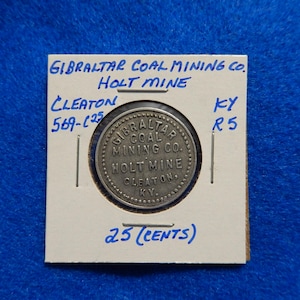 May include: A silver token with the text "Gibraltar Coal Mining Co. Holt Mine Cleaton KY" and "25 (Cents)" on a white background.