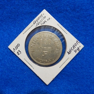 May include: A silver token with the text "Fayette Jellico Coal Co." and "100" printed on it. The token also has the text "Anchor Ky." printed on it.
