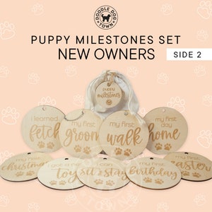 May include: A set of 10 wooden round ornaments with gold lettering and paw prints. The ornaments are for a puppy milestone set for new owners. The ornaments include phrases like "my first walk", "my first groom", "my first home", "my first birthday", "I got a new toy", "I can sit and stay", "my first Christmas", "my first Easter", "I learned fetch".