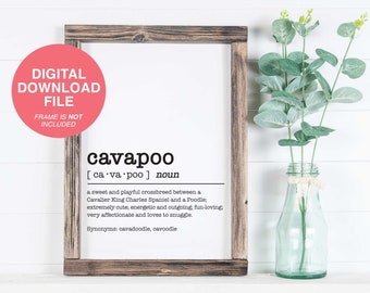 May include: A framed print with a definition of the word "cavapoo" in black text on a white background. The definition states that a cavapoo is a sweet and playful crossbreed between a Cavalier King Charles Spaniel and a Poodle. The print is in a rustic wooden frame.