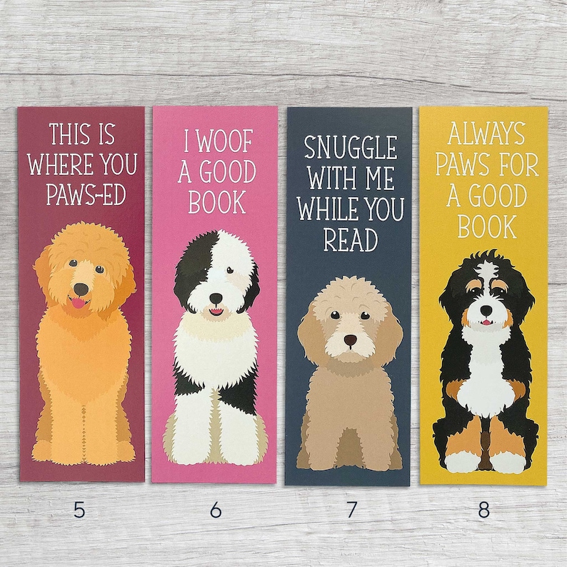 May include: Four colorful bookmarks featuring illustrations of dogs with text that reads "This is where you paws-ed", "I woof a good book", "Snuggle with me while you read", and "Always paws for a good book".