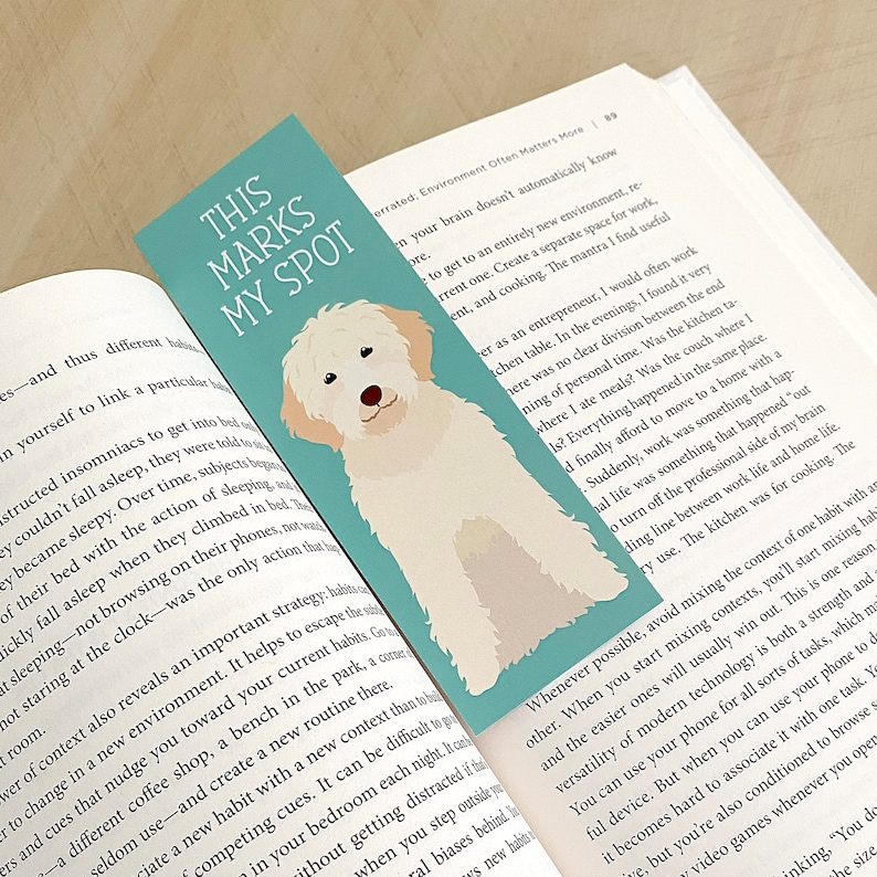 May include: A teal blue bookmark with a white dog illustration and the text "This Marks My Spot".