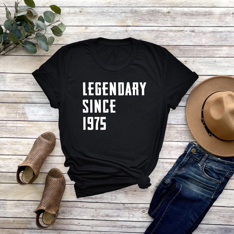 May include: Black t-shirt with white text that reads "Legendary Since 1975".