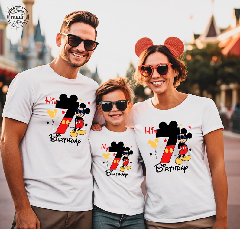 Op de afbeelding: Drie mensen dragen witte t-shirts met een Mickey Mouse-ontwerp. De shirts hebben een groot zwart nummer 7 met een rode en gele gradi&euml;nt, Mickey Mouse en de woorden "His 7th Birthday" en "My 7th Birthday".
