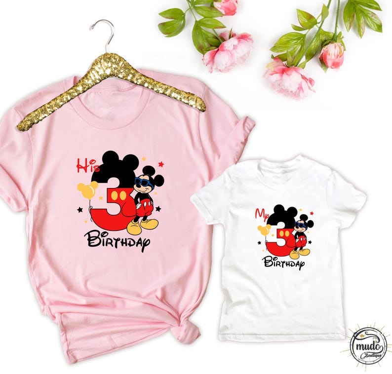 Op de afbeelding: Roze en witte T-shirts met een Mickey Mouse-afbeelding. Het roze shirt zegt "His 3rd Birthday" en het witte shirt zegt "My 3rd Birthday". Beide shirts hebben Mickey Mouse met een zonnebril en het rode nummer 3.