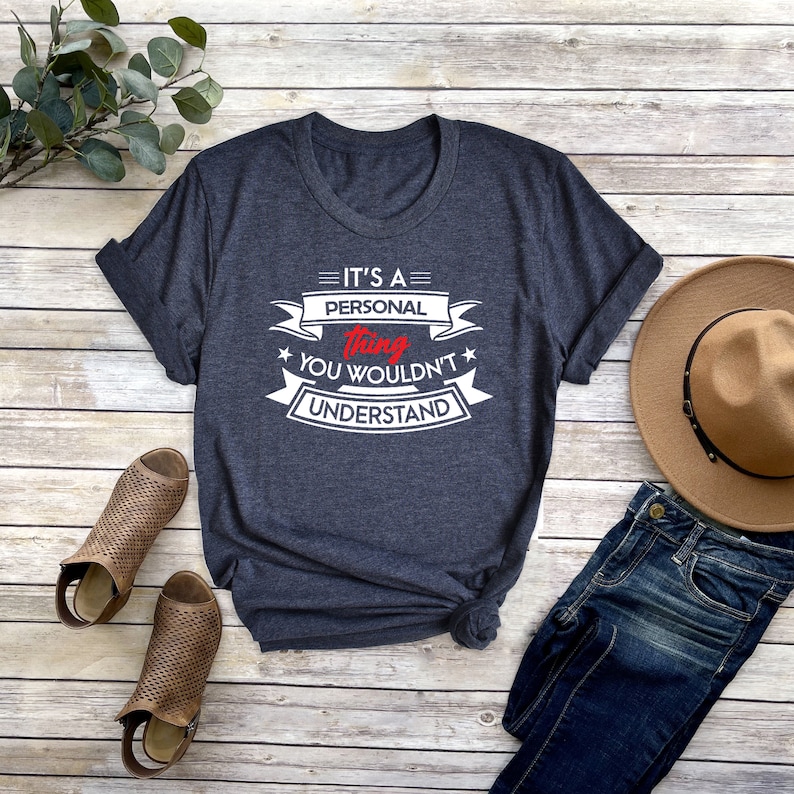 K&ouml;nnte beinhalten: Ein dunkelblaues T-Shirt mit einem wei&szlig;en Aufdruck, der "Es ist eine pers&ouml;nliche Sache, die du nicht verstehen w&uuml;rdest" sagt. Der Aufdruck ist im Vintage-Stil mit roten Akzenten.