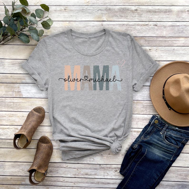 May include: Gray t-shirt with the word "MAMA" in colorful block letters and the text "Oliver &hearts; Michael" underneath.