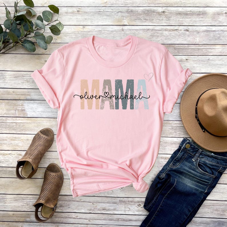 May include: Pink t-shirt with the word "MAMA" in rainbow colors and the names "Oliver" and "Michael" written below.