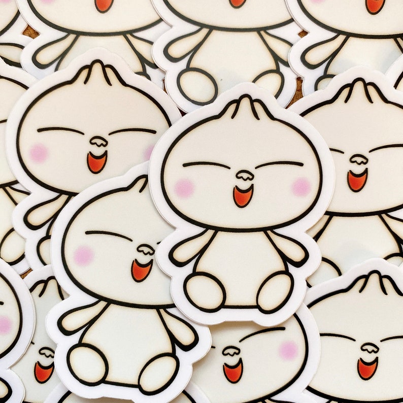 May include: A stack of white stickers with a cartoon character design. The character has a round body, black eyes, a red mouth, and pink cheeks. The character is smiling with its eyes closed.