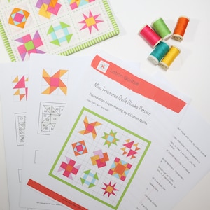 Peut inclure: Un patron de blocs de courtepointe Mini Treasures de Lisbon Quilts imprim&eacute; sur papier blanc, avec des motifs g&eacute;om&eacute;triques color&eacute;s. Cinq bobines de fil rose, vert, orange, bleu sarcelle et jaune accompagnent un petit &eacute;chantillon de tissu.