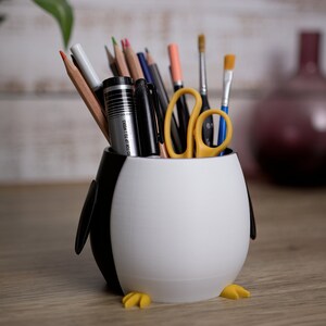 Elevate your workspace with our charming 3D printed Penguin Pen Holder Pots. They keep your utensils organized and serve as a delightful gift for loved ones.