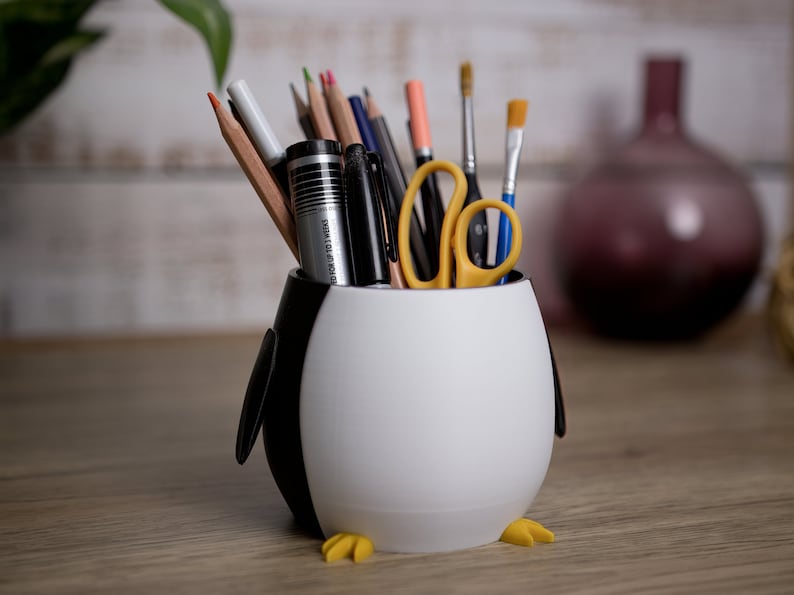 Elevate your workspace with our charming 3D printed Penguin Pen Holder Pots. They keep your utensils organized and serve as a delightful gift for loved ones.