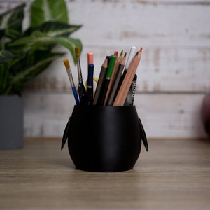 Discover our 3D printed Penguin Pen Holder Pots to enhance your desk. Ideal for holding pens and brushes, they add fun and organization to your workspace.