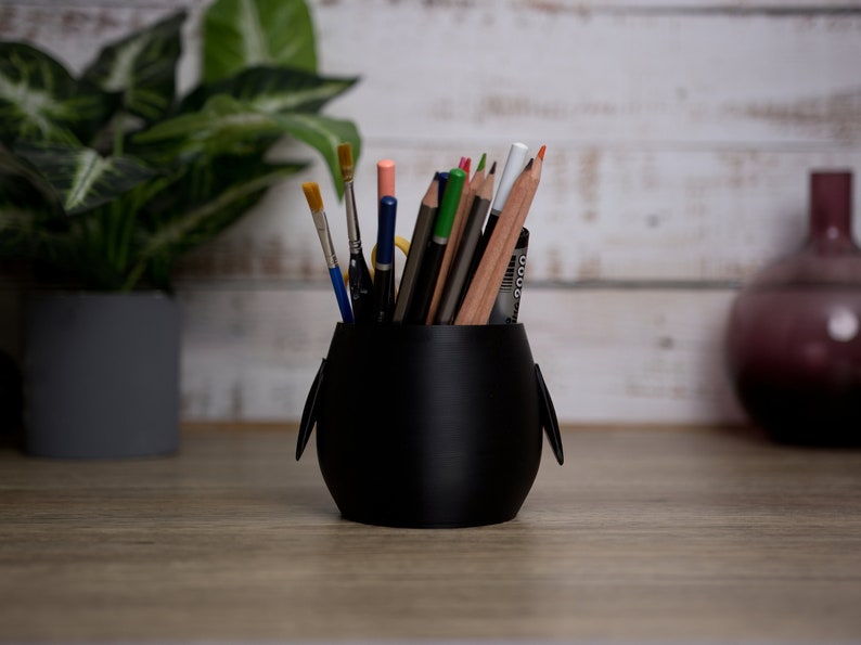 Discover our 3D printed Penguin Pen Holder Pots to enhance your desk. Ideal for holding pens and brushes, they add fun and organization to your workspace.