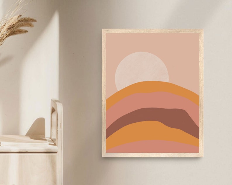May include: Abstract art print with a pink, orange, and brown color scheme. The print features a large white circle in the center and a series of curved lines that resemble hills.
