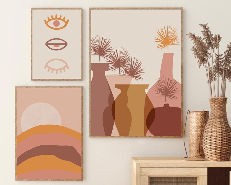 May include: Three abstract art prints with a minimalist design featuring geometric shapes and muted colors. The prints are framed in natural wood and hung on a white wall.