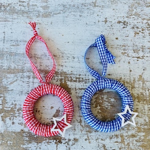 May include: A white ceramic mug with a black handle and the text "But first, coffee" in a black, handwritten-style font. The mug is on a white surface.