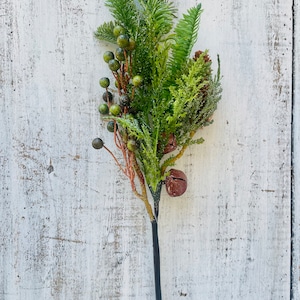 May include: A green and brown artificial floral sprig with berries and bells. The sprig is perfect for adding a touch of greenery to your home decor.