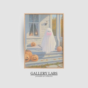 May include: A framed art print featuring a white ghost wearing a pink bow standing on a porch with orange jack-o'-lanterns. The scene depicts a house exterior with a window and autumn leaves. Below the image, the text reads GALLERY LABS printable art collective.