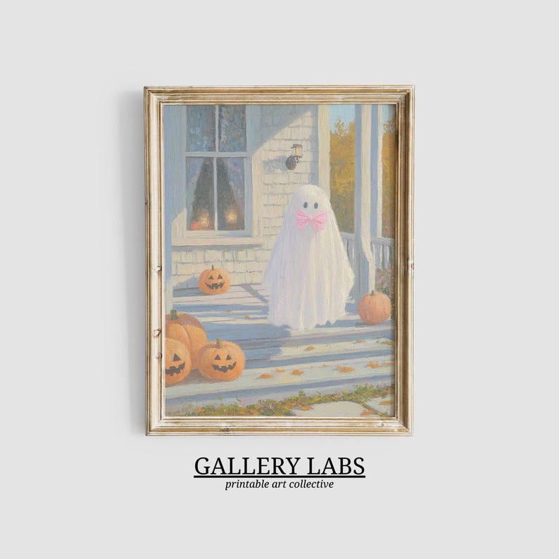 May include: A framed art print depicting a white ghost wearing a pink bow standing on a porch with orange jack-o'-lanterns. The scene features a house exterior with a window and autumn foliage in the background. The text GALLERY LABS is below.