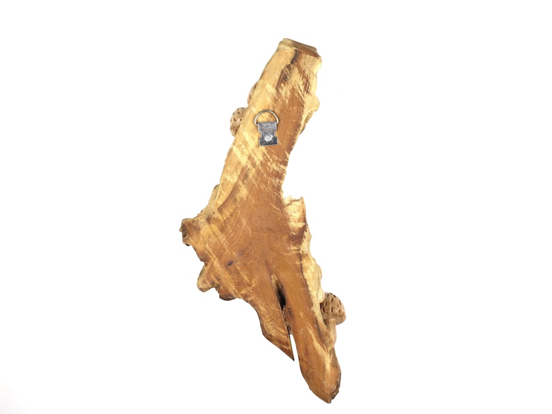 May include: A natural wood wall decor piece with a unique shape and a hanging hook on the back.
