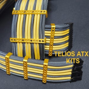May include: Black and gold braided computer cables with gold metal connectors and decorative accents. The cables are labeled "TELIOS ATX KITS".