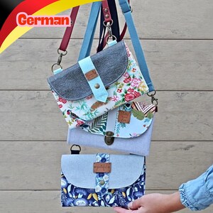 Könnte beinhalten: Drei rechteckige Umhängetaschen mit verstellbaren Riemen. Die obere Tasche hat einen Blumendruck und eine dunkel texturierte Klappe. Die mittlere Tasche besteht aus hellblauem Stoff mit einer botanischen Klappe. Die untere Tasche zeigt ein dunkelblaues Blumenmuster.