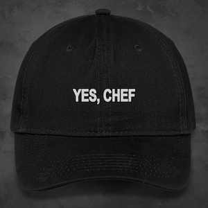 May include: A black baseball cap with a white embroidered phrase "YES, CHEF" on the front.