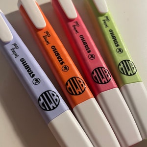 Pu&ograve; includere: Quattro evidenziatori Stabilo Swing Cool nei colori pastello viola, arancione, rosa e verde chiaro. Ogni pennarello presenta un cappuccio bianco, una clip da taschino bianca e un logo circolare nero con le lettere MWB sul corpo colorato.