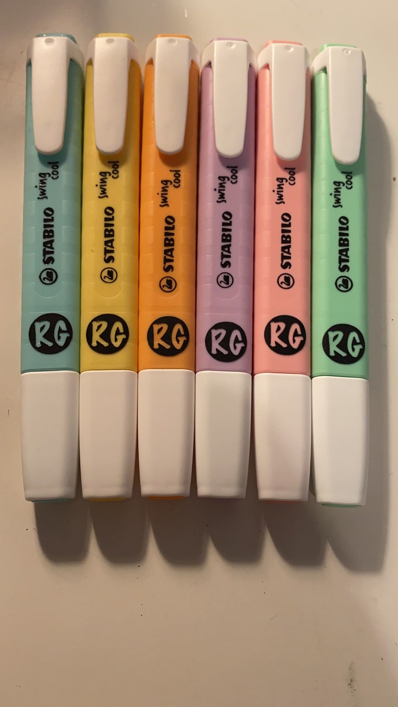 Pu&ograve; includere: Un set di sei evidenziatori Stabilo Swing Cool in blu pastello, giallo, arancione, viola, rosa e verde. Ogni pennarello presenta un cappuccio bianco, una clip da taschino bianca e un logo circolare nero con le lettere RG sul fusto.