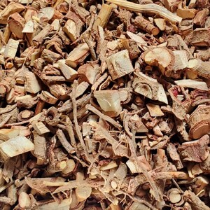 May include: A close-up of a pile of dried, brown, and reddish-brown roots and bark. The pieces are of various sizes and shapes, some are long and thin, others are short and thick.