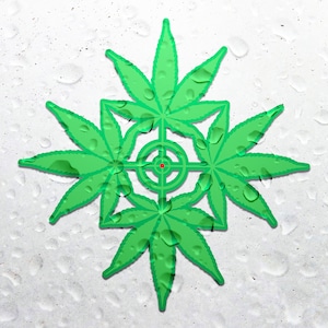 May include: A green marijuana leaf design with a target in the centre, surrounded by water droplets on a white background.