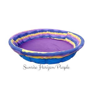 May include: A blue and purple inflatable pool with a colorful sunrise horizon print. The text "Sunrise Horizon/Purple" is printed below the pool.